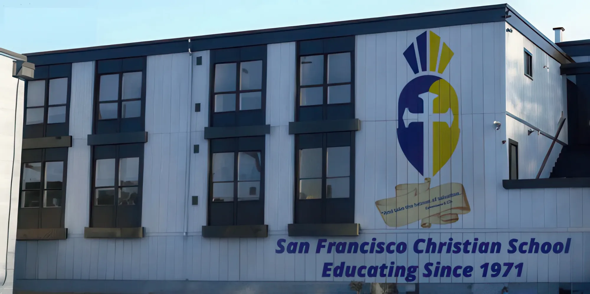 The repainted school building carrying the Trojan helmet mural and the words San Francisco Christian School, Educating Since 1971