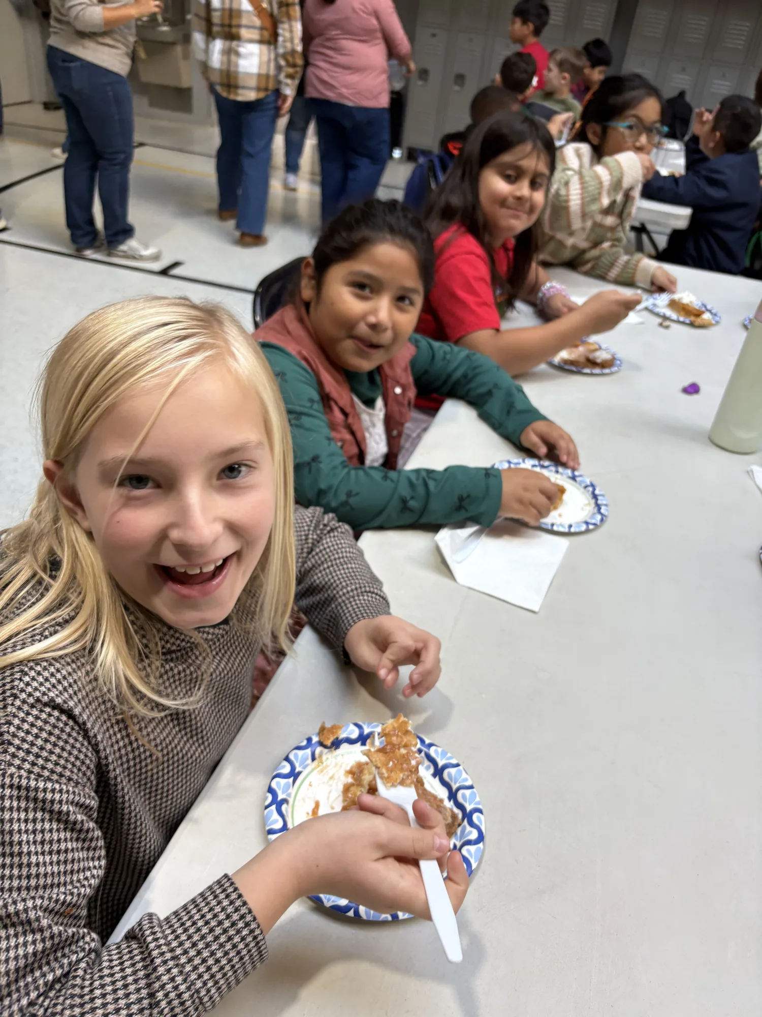 A student beaming at the camera during a class feast